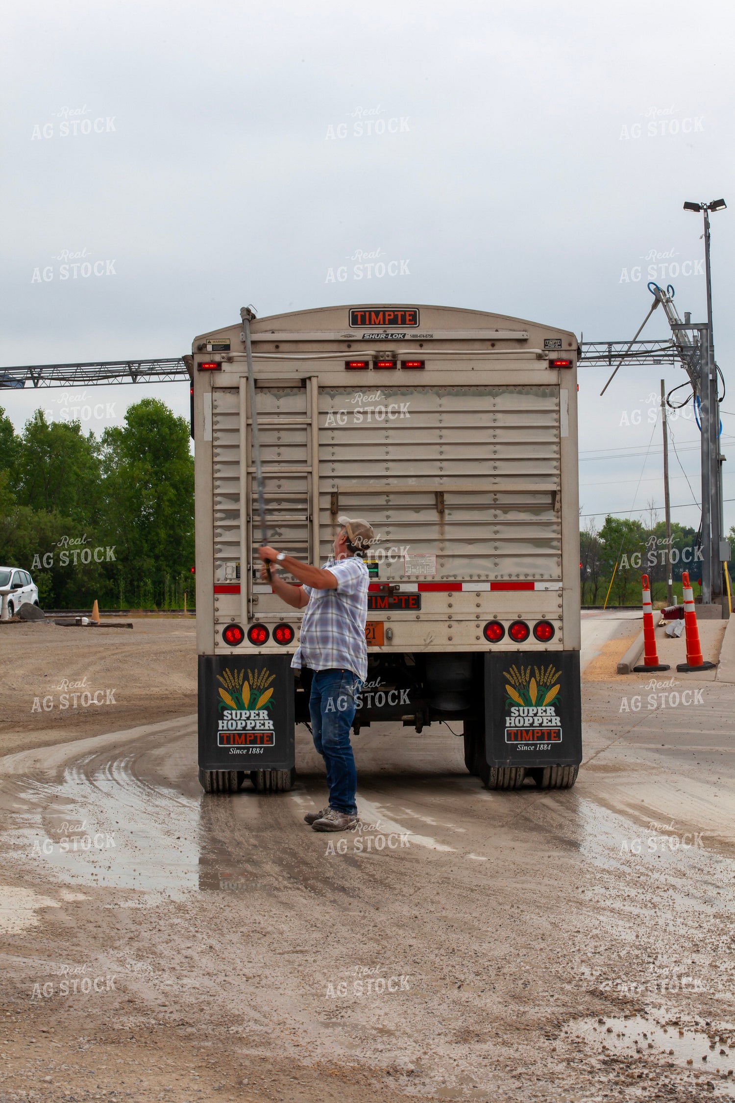 Farmer Rolling Tarp Out onto Semi Truck 132084