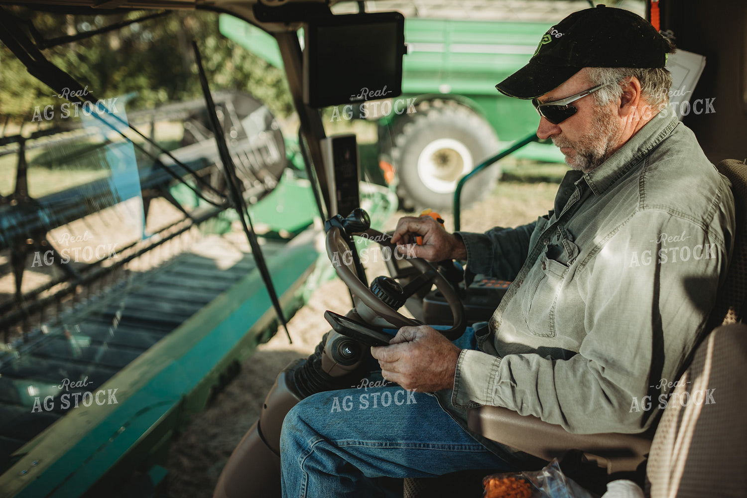 Farmer Looking at Phone in Combine Cab 5229