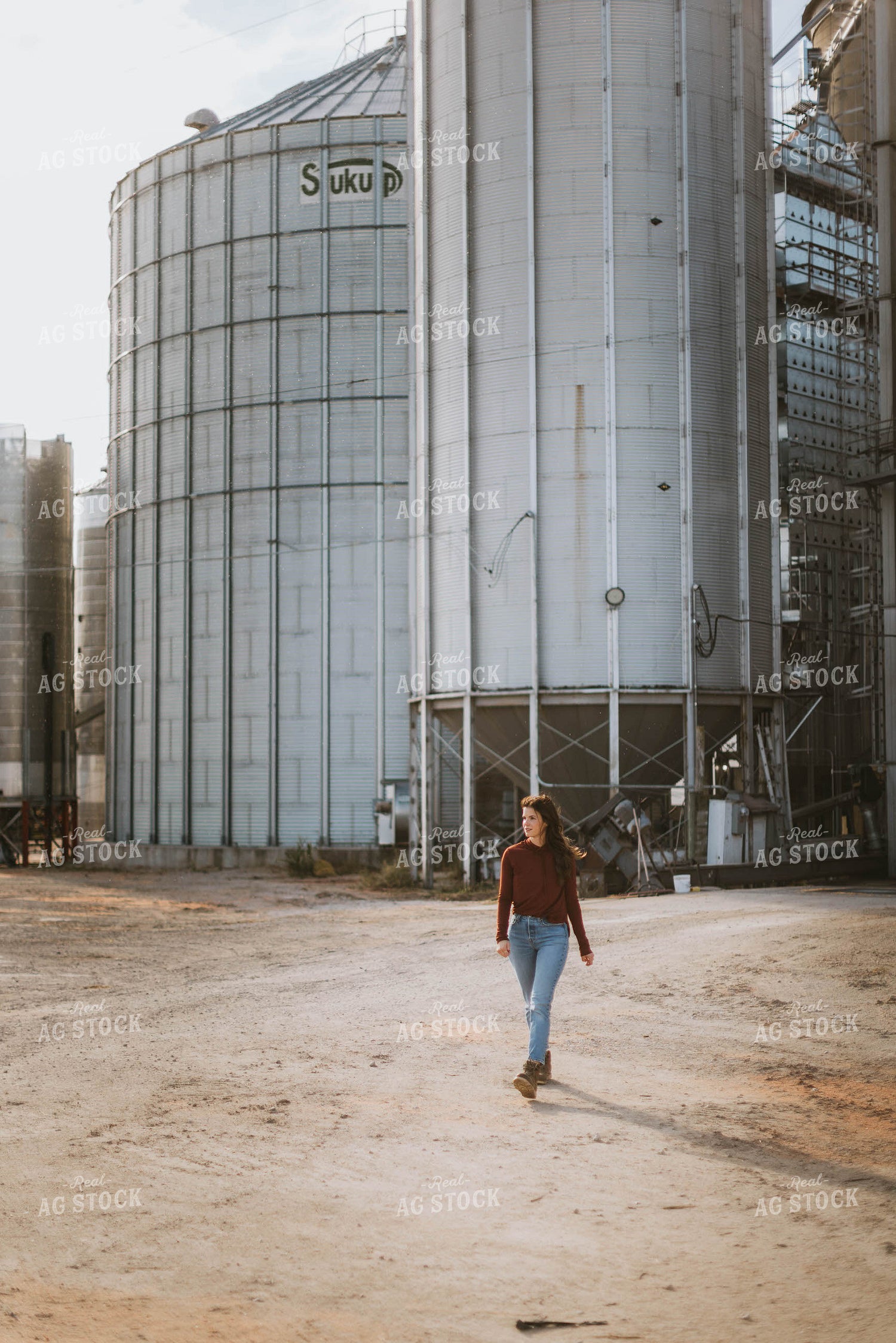 Female Farmer Walking by Grain Bins 8493