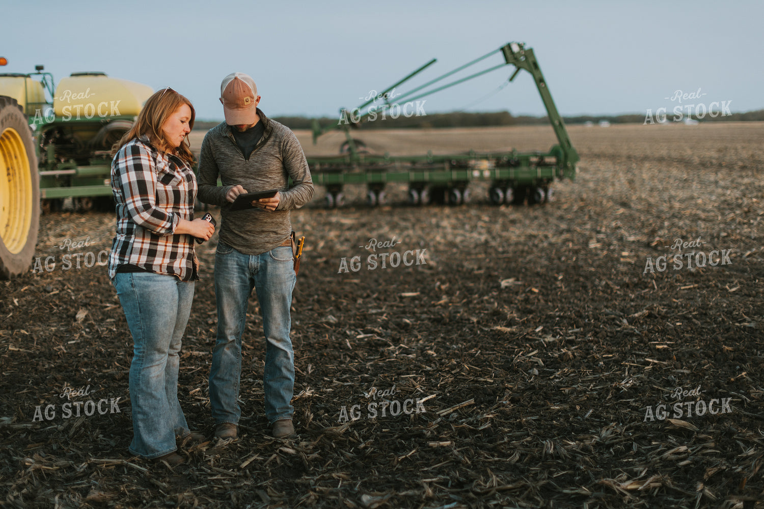 Farmers using Tablet in Field by Planter 8259