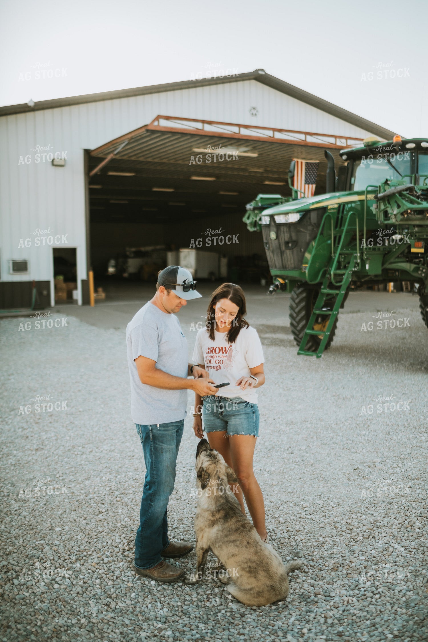 Farmer and Farm Wife Talking Outside Shop Looking at Phone 6239