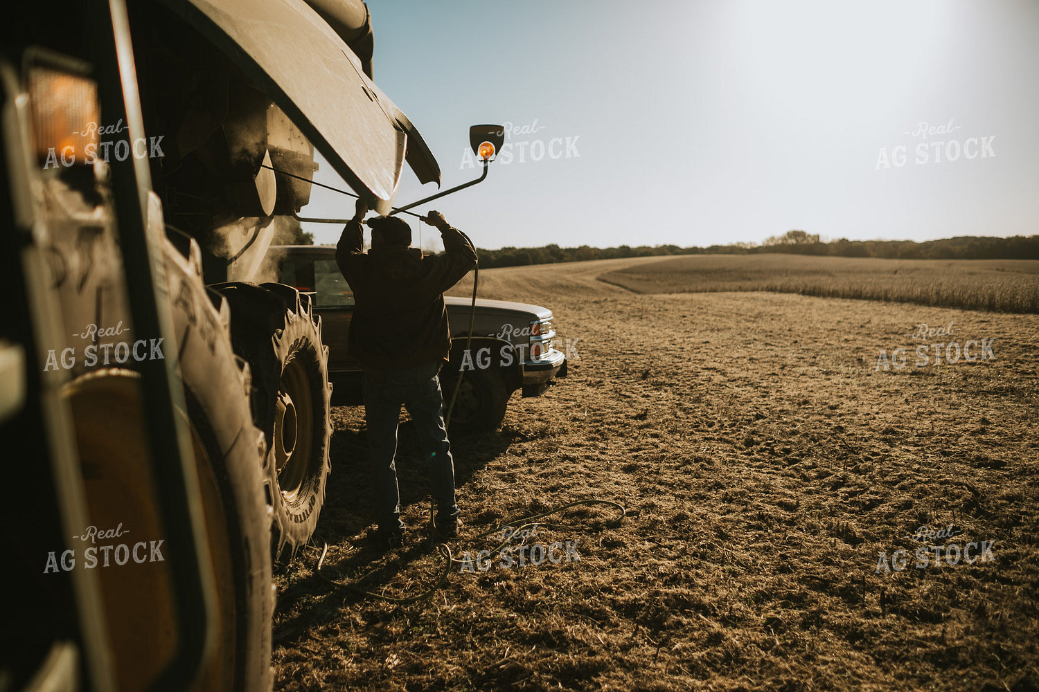 Farmer Using Air Hose to Clean Combine During Soybean Harvest 5195