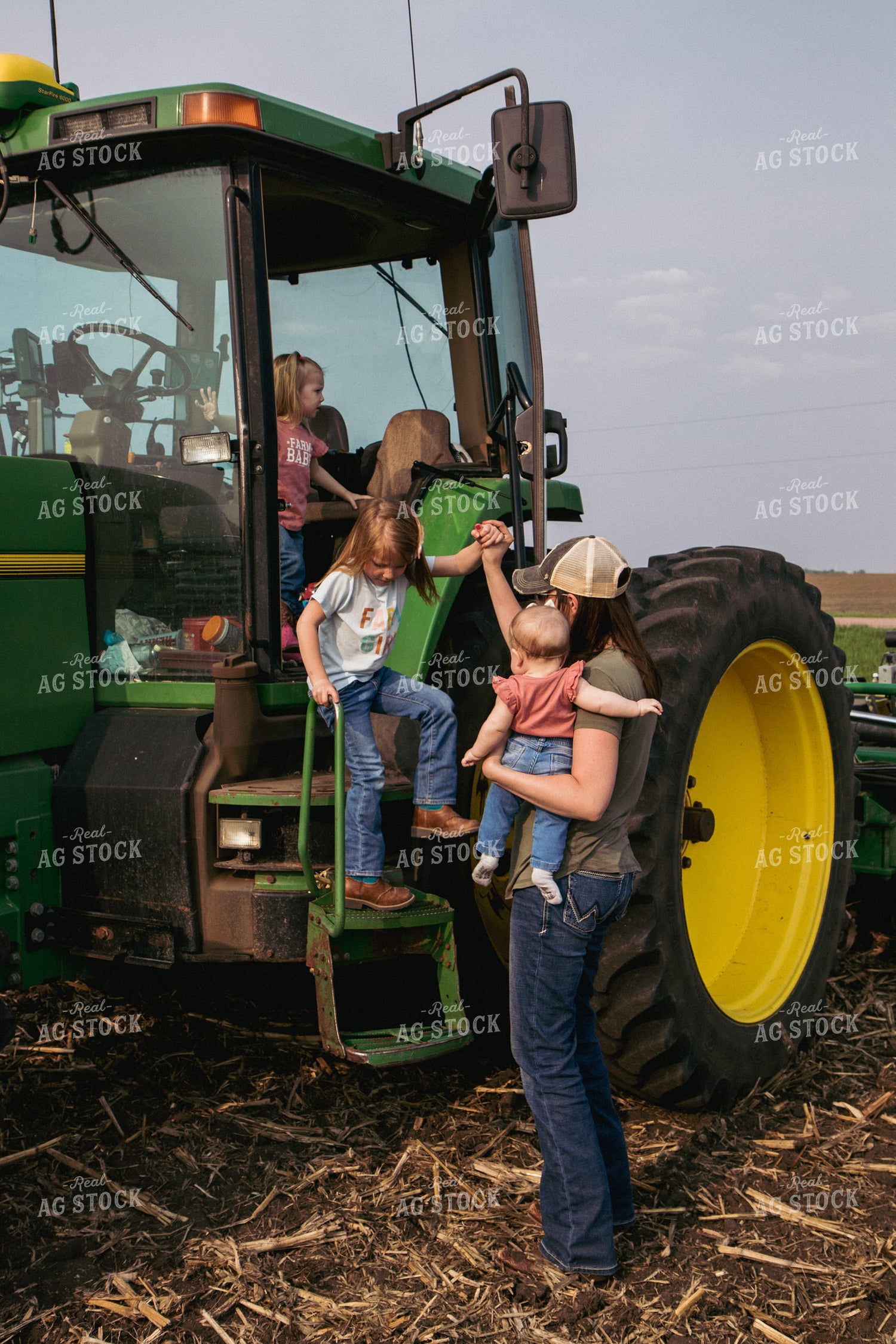 Female Farmer Helps Daughters Down Tractor Ladder in Freshly Planted Field 67299