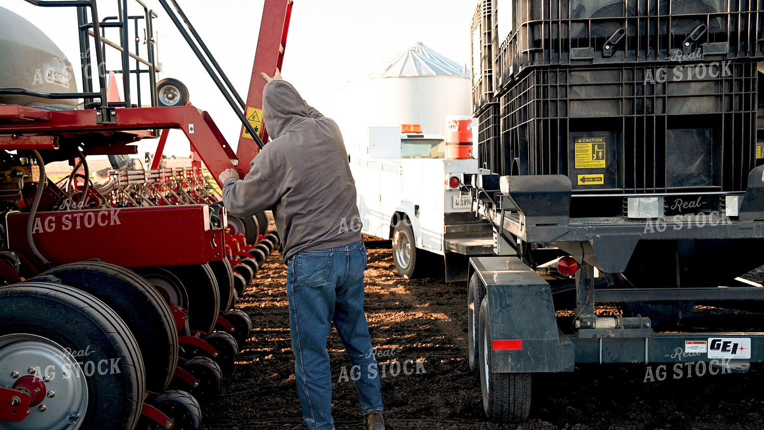 Farmer Loading the Planter with the Seed Tender 25186