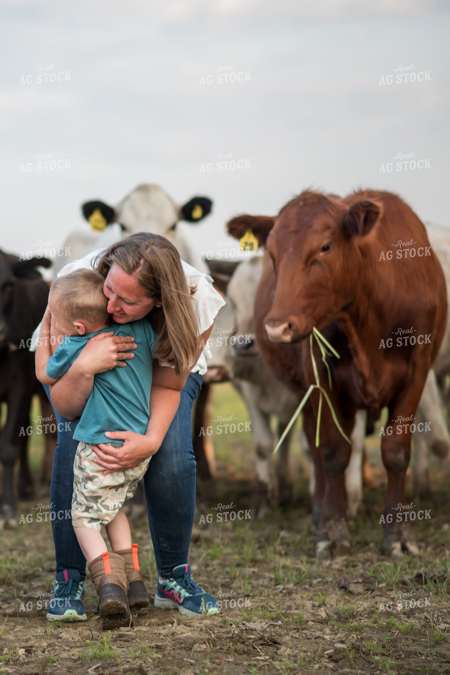 Female Farmer Hugging Kid in Cattle Pasture 76559