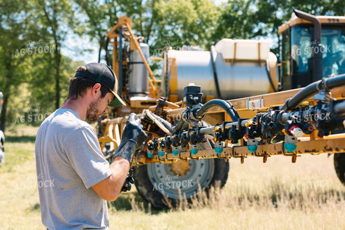 Farmer Fixing Sprayer Nozzles 52723