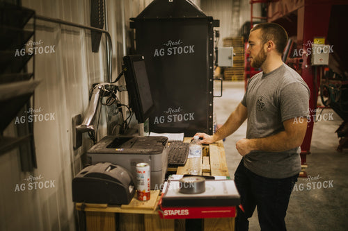 Man Running Computer Program for Treating Seed 5294