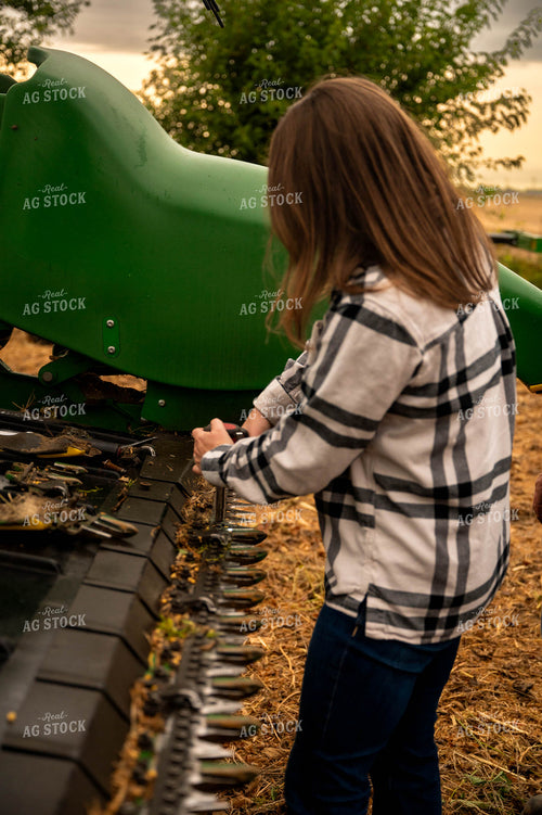Female Farmer Fixing Combine Head 115414