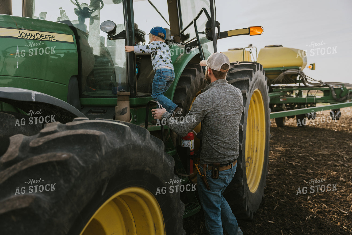 Farmer Climbing into Tractor with Son 8182