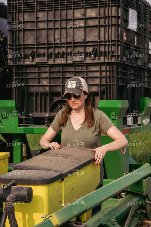 Female Farmer Loading Planter Boxes with Seed 67303
