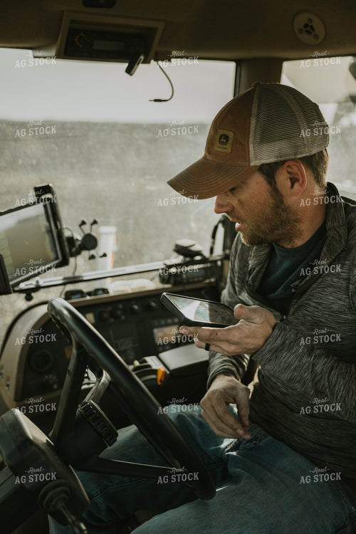Farmer in Tractor Cab using Phone 8187