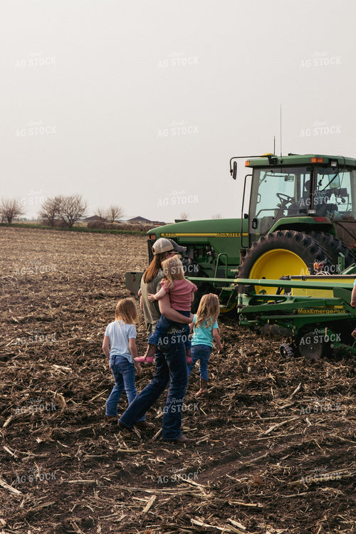 Female Farmer Holds Children in Field by Tractor and Planter 67296