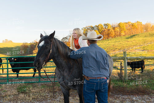 Rancher Helping Daughter Get on Horse 52818