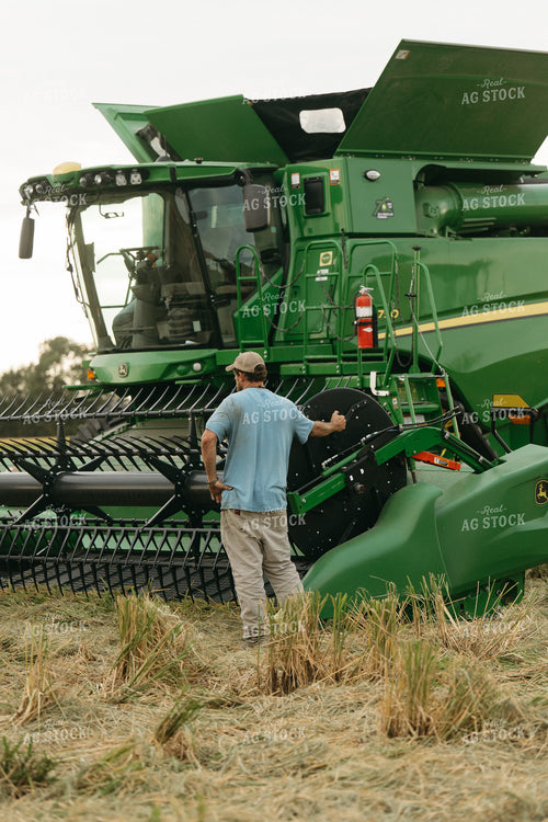 Farmer Fixing Combine in Rice Field 125267