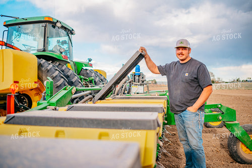 Farmer Opens Seed Hopper in Field During Planting 56655
