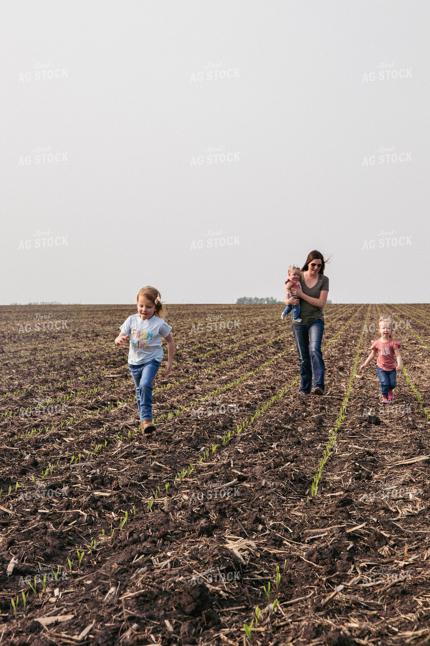 Female Farmer and Daughters Play in Emerging Corn Field 67290