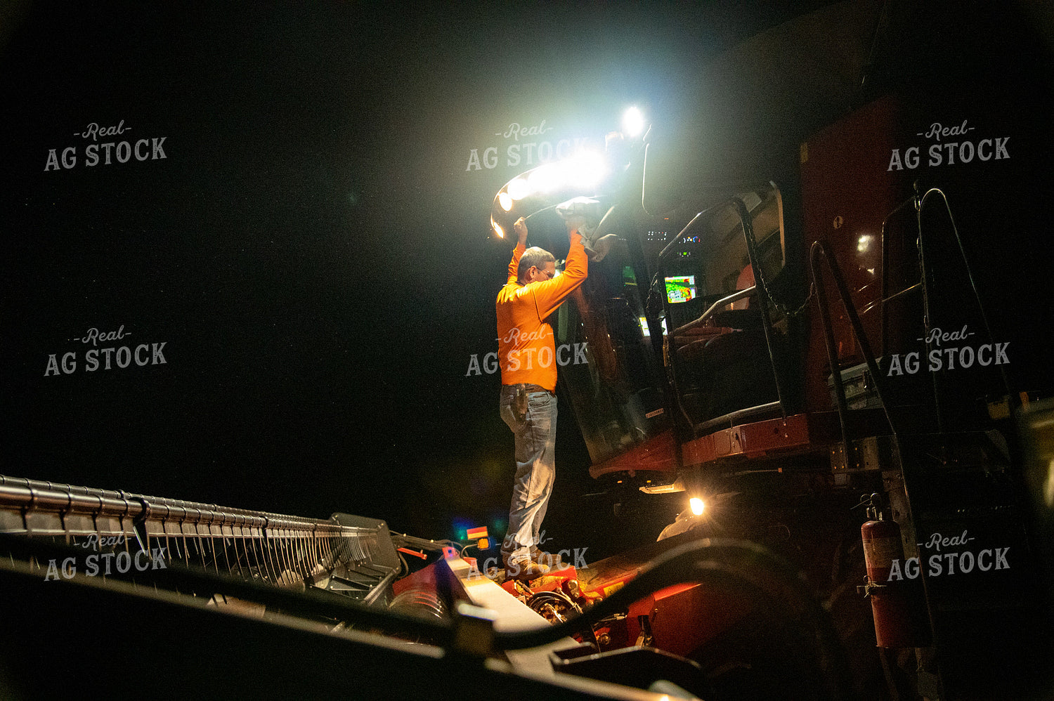 Farmer Cleaning Dust off Combine at Night 25804
