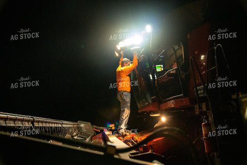 Farmer Cleaning Dust off Combine at Night 25804