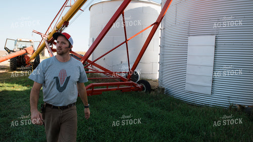Farmer Walking by Bins 26092