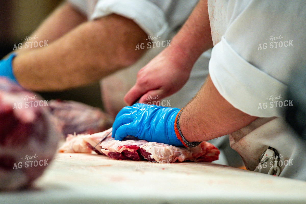 Meat Processing Worker Butchering Raw Cuts on Cutting Board 414000