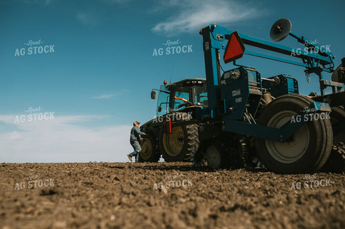Farmer Climbing into Tractor with Planter 4101