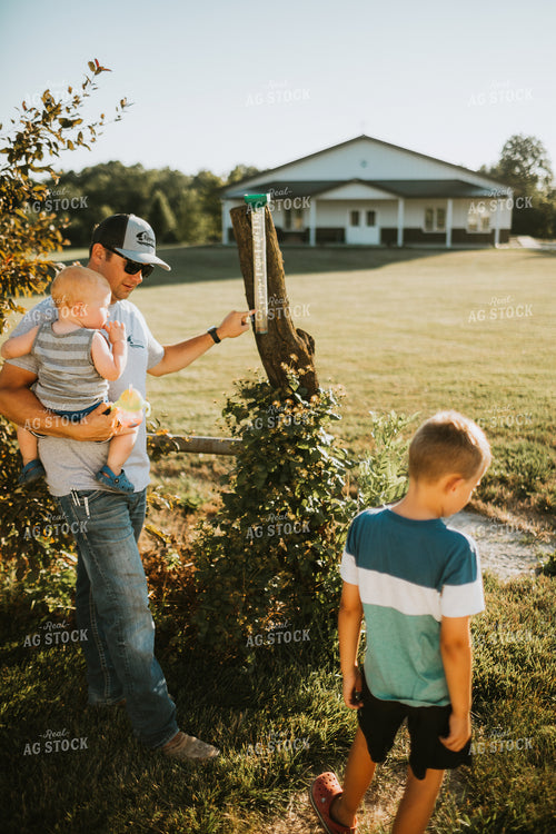 Farm Family Checking Rain Gauge 6261