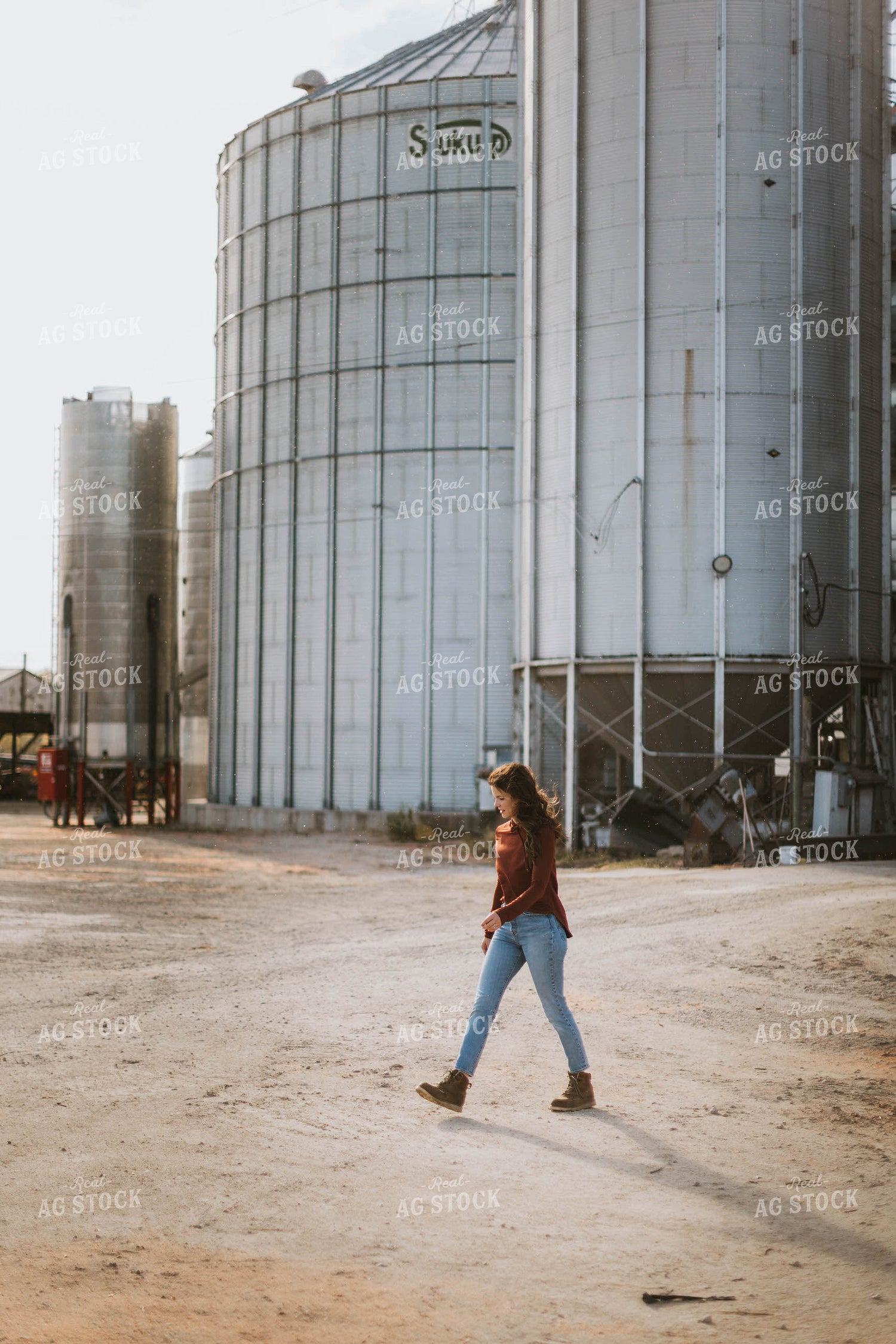Female Farmer Walking by Grain Bins 8494