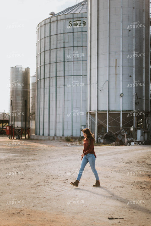 Female Farmer Walking by Grain Bins 8494