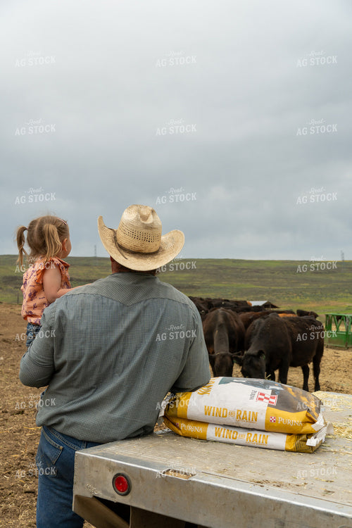 Farmer with Child Observing Cattle on a Rural Farm Landscape 65264