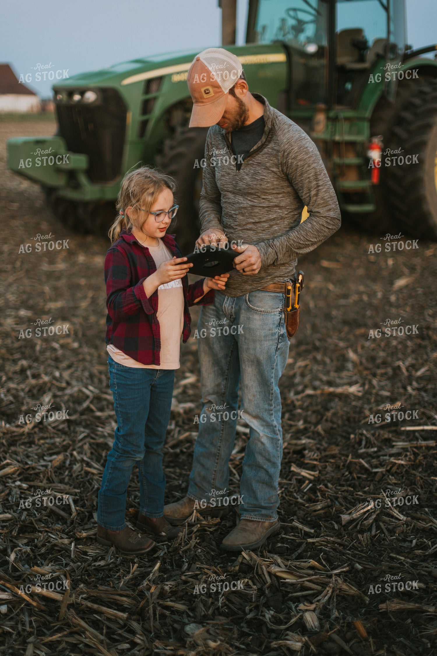 Farmer using Tablet in Field by Planter with Daughter 8261