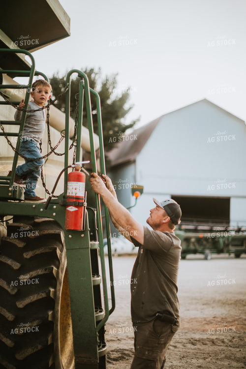 Farmer Working on Combine with Farm Kid 5129