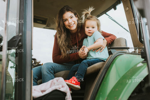 Female Farmer with Daugther in Tractor 8573