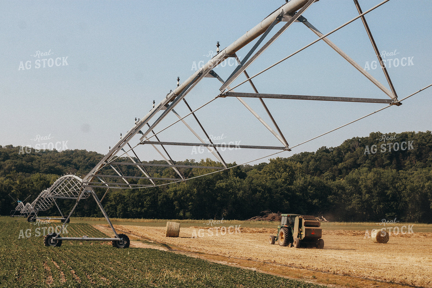 Tractor Bales Hay Alongside Irrigated Soybean Field 101028