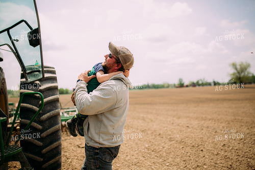 Farmer Helping Son Out of Tractor 169080
