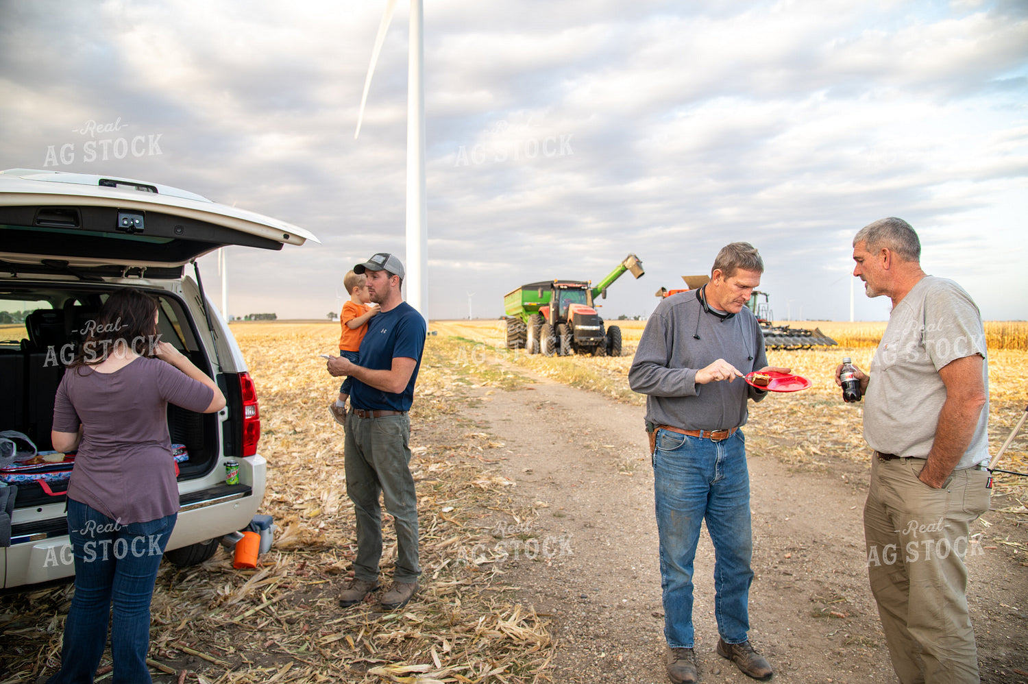 Family Enjoying Harvest Meal in the Field 25820