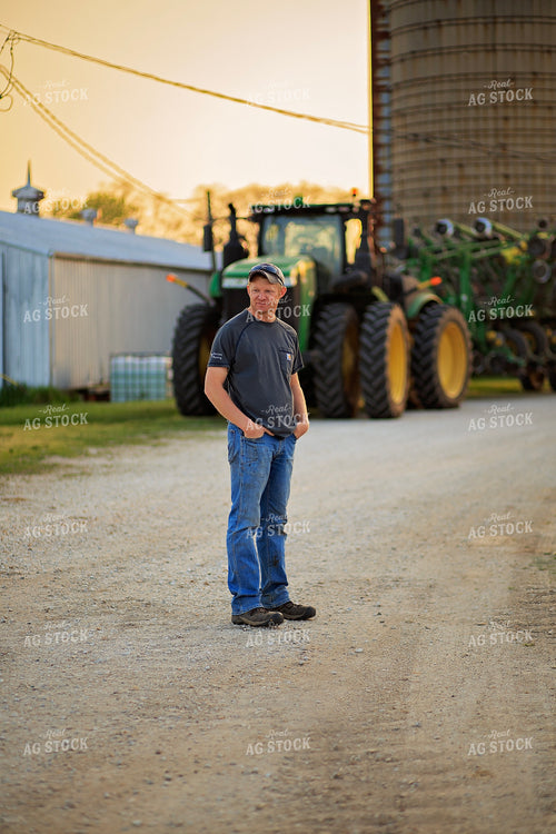 Farmer Stands in Front of Tractor 93197