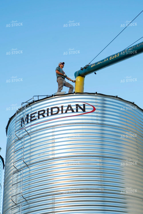 Farmer Lining Up Auger on Bin 187249