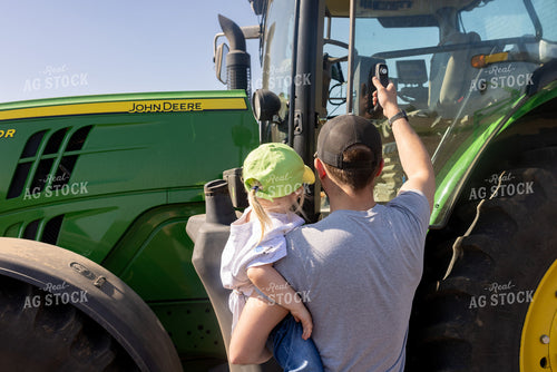 Farmer and Daughter Climbing into Tractor 161174