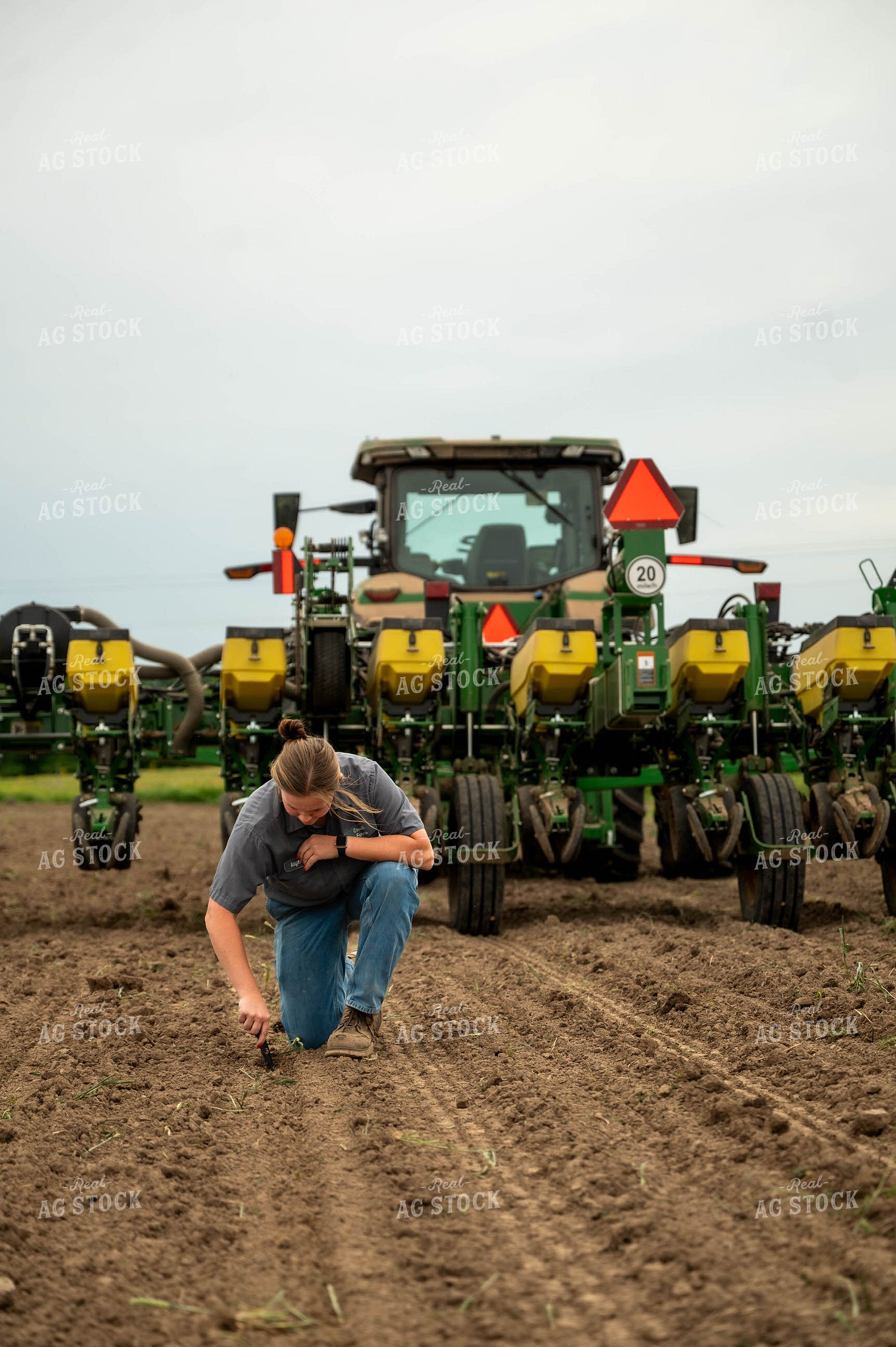 Female Farmer Checking Seed Depth Behind Planter 115696