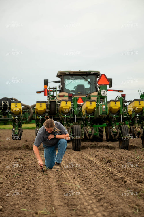 Female Farmer Checking Seed Depth Behind Planter 115696