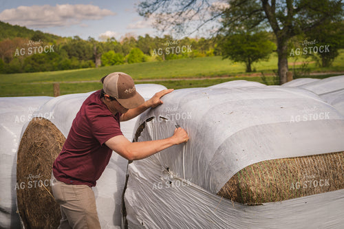 Farmer Unwrapping Hay Bales 128014