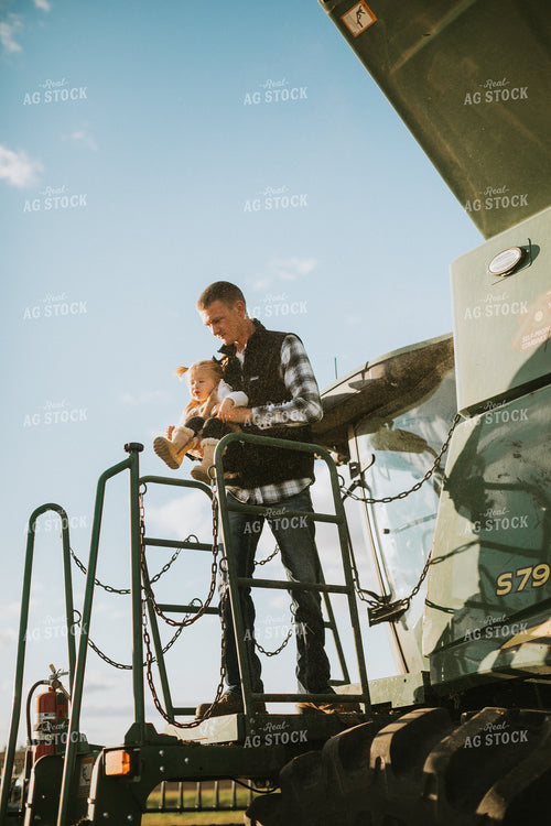 Farmer Holding Daughter on Combine Ladder 6870