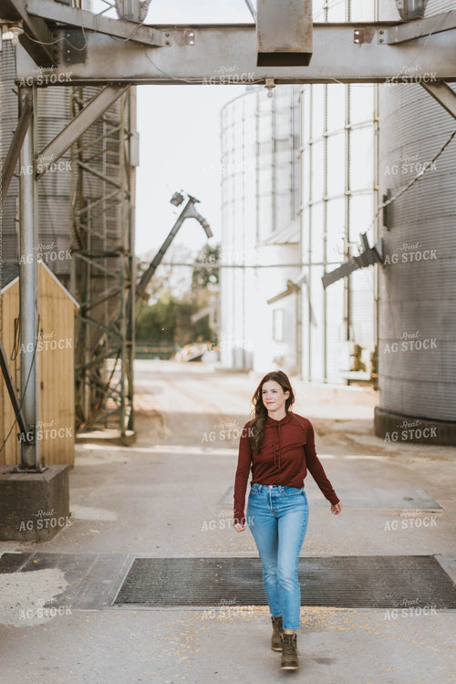 Female Farmer Walking by Grain Bins 8490