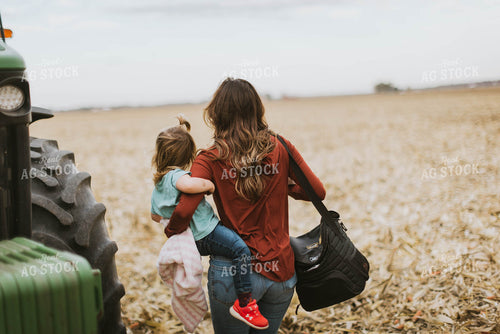 Female Farmer with Daugther Climbing into Tractor 8569
