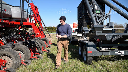 Farmer Loading the Planter with the Seed Tender 25118
