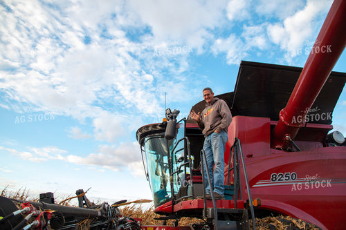 Farmer Climbing into Combine Cab and Waving 25578