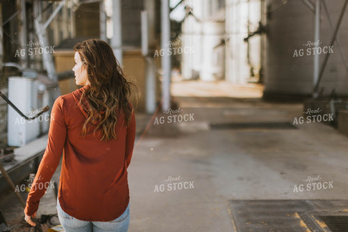 Female Farmer Walking by Grain Bins 8496