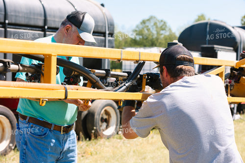 Farmer Fixing Sprayer Nozzles 52724