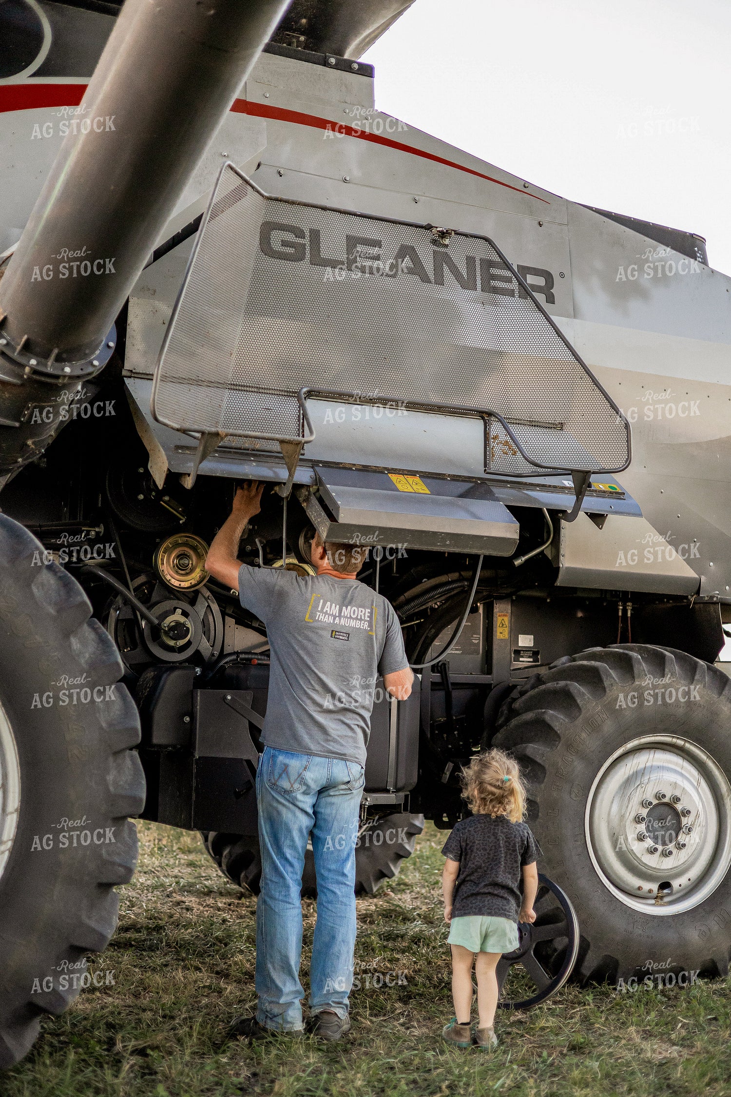 Farmer and Farm Kid Working on Combine 93344