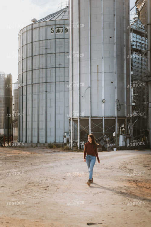 Female Farmer Walking by Grain Bins 8493